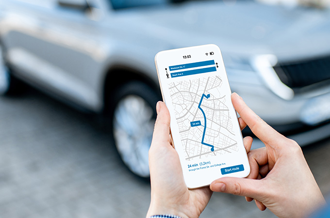 person holding a smartphone displaying a map with route directions to college with estimated travel time of 24 minutes and distance of 2.3 kilometers 7 travel tips for navigation